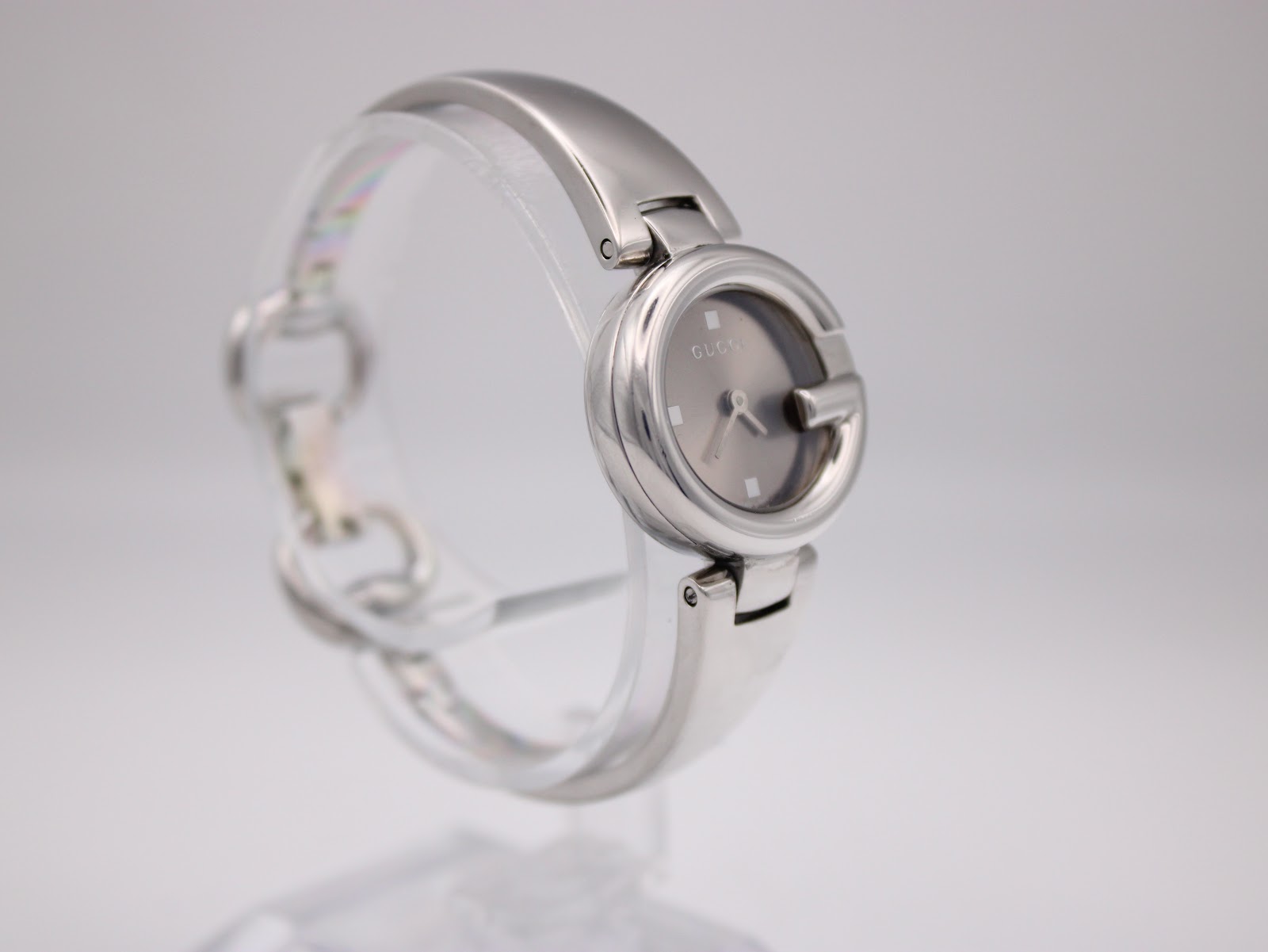 Another angled side view of the Gucci 134.5 watch from the opposite side, highlighting the polished finish and bracelet design.