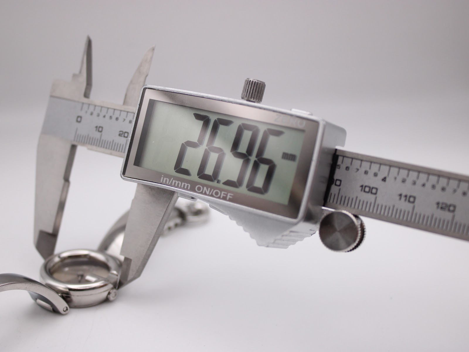 Digital caliper measuring the case diameter of the Gucci 134.5 watch, displaying an exact measurement of 26.96mm.