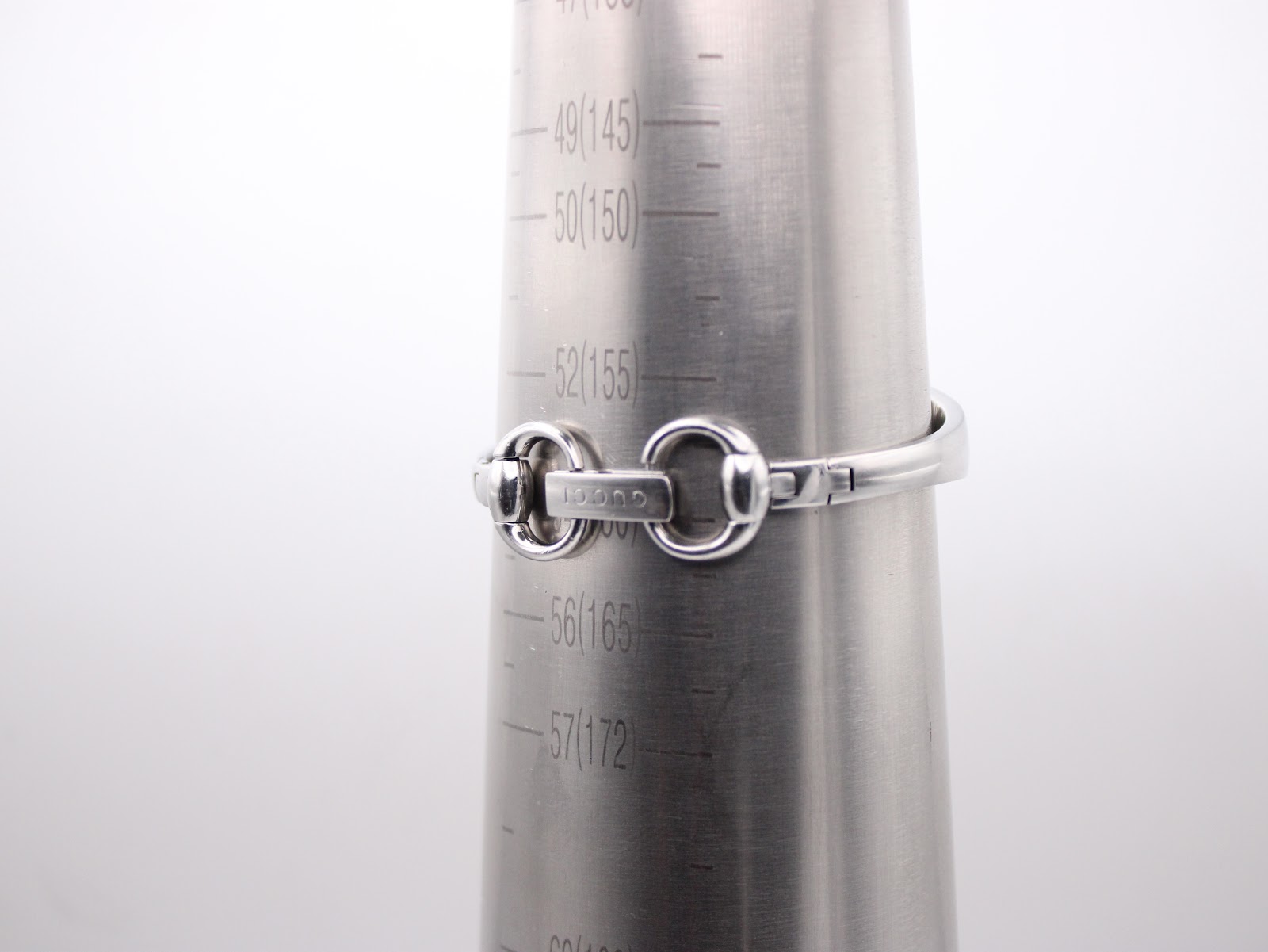 The Gucci watch bracelet wrapped around a metal wrist sizing cone, indicating a wrist circumference of approximately 16.5cm.
