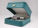 The Gucci 134.5 watch resting inside a generic teal jewellery presentation box, open on a white background.