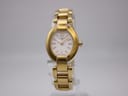 Front view of a gold-tone Tissot G332 watch with a white oval dial and baton indices, on a clear display stand.
