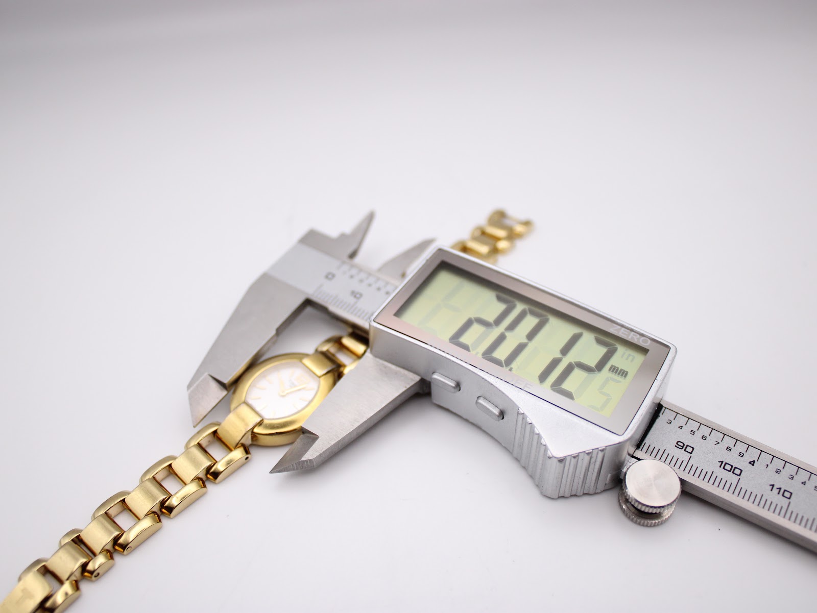 Digital caliper measuring the case diameter of the Tissot watch, displaying a precise measurement of 20.12mm.