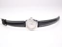 Full front view of the Tissot watch with its black leather strap extended, presented against a white background.
