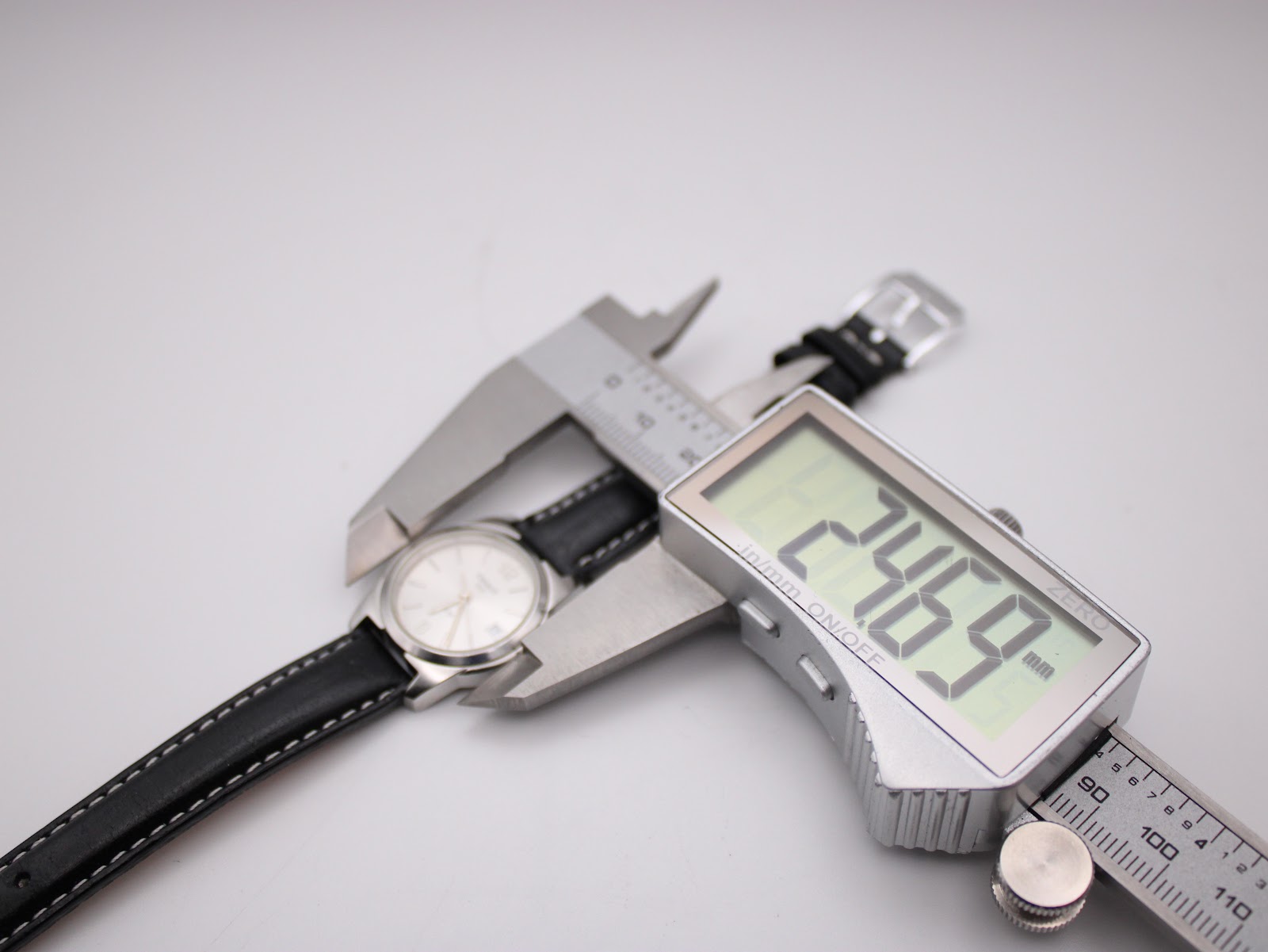 Digital caliper measuring the case diameter of the Tissot watch at 24.69mm.