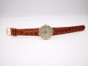 Overhead view of the Tissot T890K watch laid flat, displaying the entire brown croc-effect leather strap and gold-tone buckle.