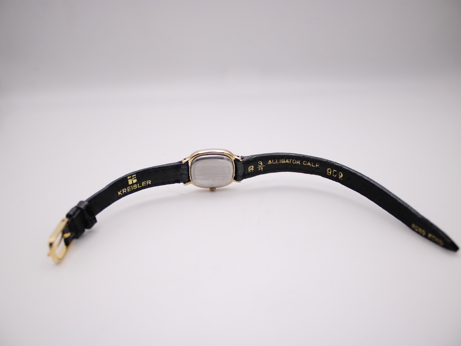 Rear view of Tissot watch case back with stainless steel detail.