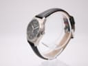 Right side profile of the Tissot watch showing the crown and brushed titanium case on a display stand.