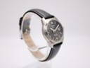Left side profile of the Tissot watch showing the brushed titanium case on a display stand.