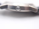 Macro shot of the Tissot 'T' signed crown on the side of the titanium watch case.