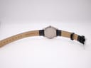 Underside view of the Tissot watch showing the case back and 'genuine leather' strap with 14mm lug width visible.