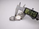 Close-up of a digital caliper measuring the watch's bezel diameter, displaying a precise reading of 28.32mm.