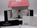 Tissot T023210A watch resting on its cushion inside the original red and black Tissot box, with a guarantee card showing the purchase date.