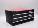 Angled view of the Tissot original presentation box, black with a red top and white 'Tissot' branding on the drawers.
