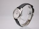 Side profile view of the Tissot T023210A watch on a clear display stand, highlighting the sculpted silver case and crown.