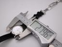 Digital caliper measuring the Tissot watch case diameter, displaying an exact measurement of 27.96mm on a white background.