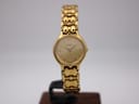 Front view of the Tissot E421K gold tone ladies quartz watch on a display stand, showcasing its champagne dial and integrated bracelet.