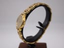Side profile of the gold Tissot watch, highlighting the crown and the elegant curve of the case and bracelet links.