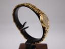 Another side profile view of the Tissot E421K, showing the continuous flow of the integrated gold tone bracelet.