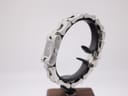Side view of the Gucci 2300L on a stand, showing the case profile and integrated link bracelet.