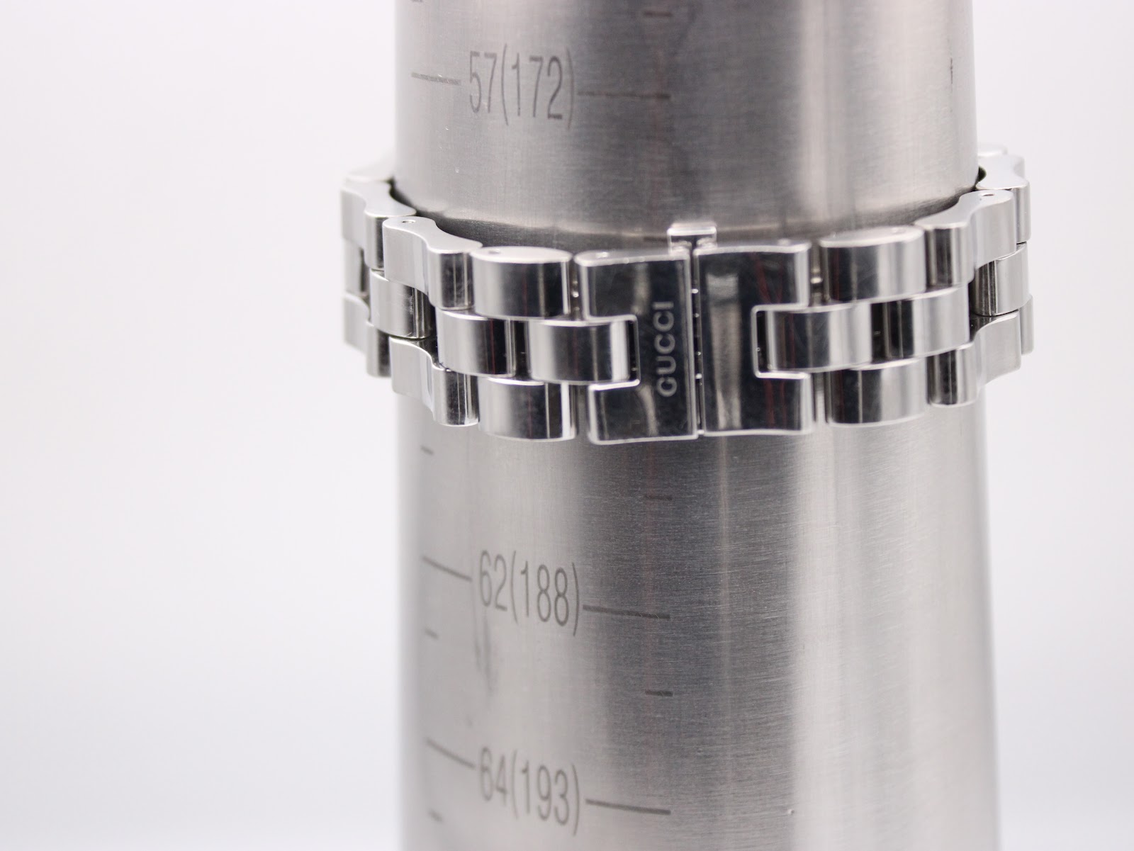 Close-up of the Gucci 2300L bracelet clasped around a wrist sizing gauge, indicating a wrist size of approximately 172mm.