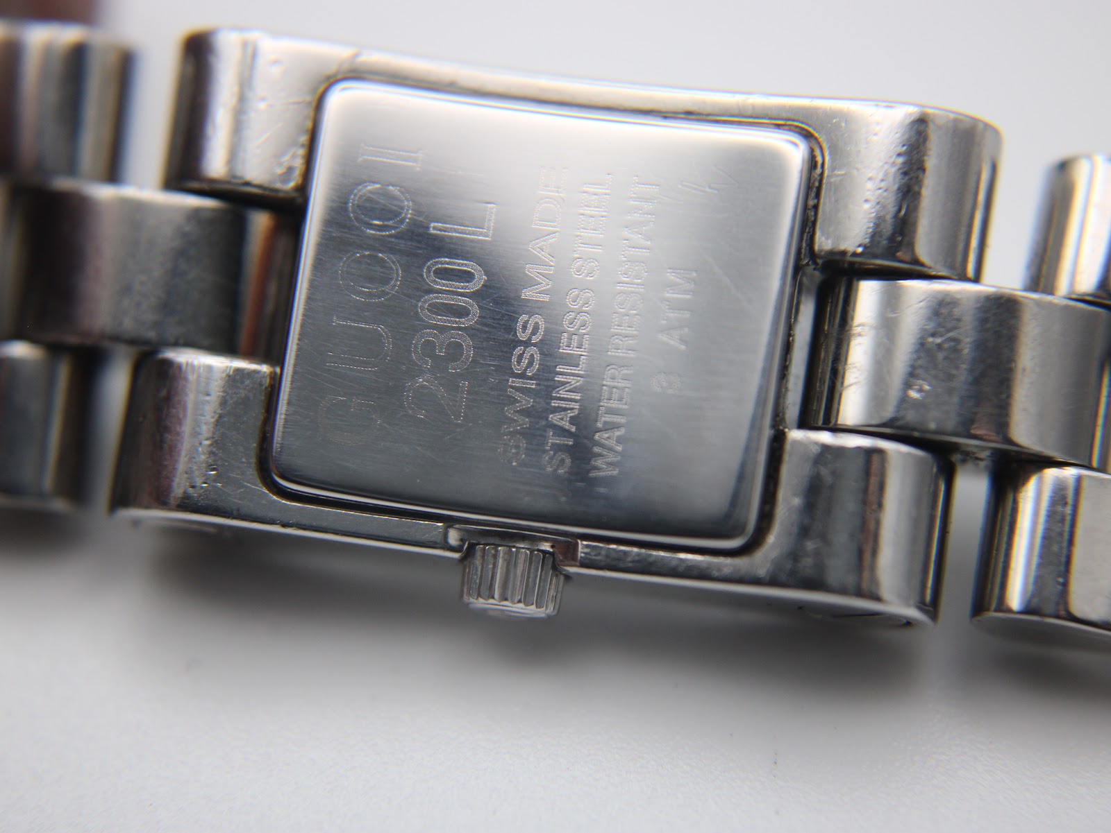 Close-up of the case back engraving on the Gucci 2300L, showing 'GUCCI 2300L SWISS MADE STAINLESS STEEL WATER RESISTANT 3 ATM'.