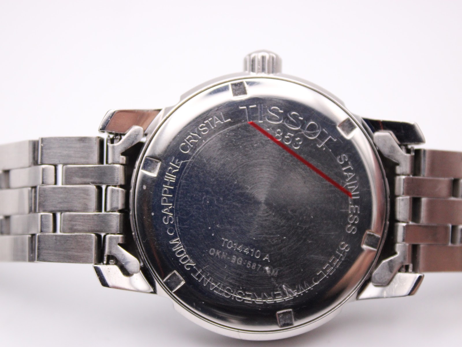 Close-up of the stainless steel case back of the Tissot PRC 200, with 'TISSOT 1853' and 'WATER RESISTANT 200M' engravings visible.
