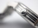 Macro close-up of the Tissot watch crown, showing the 'T' logo engraving.