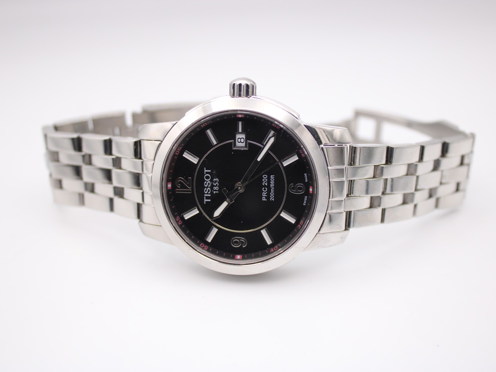 Full view of the Tissot PRC 200 watch with its stainless steel bracelet unfurled, presented on a white background.