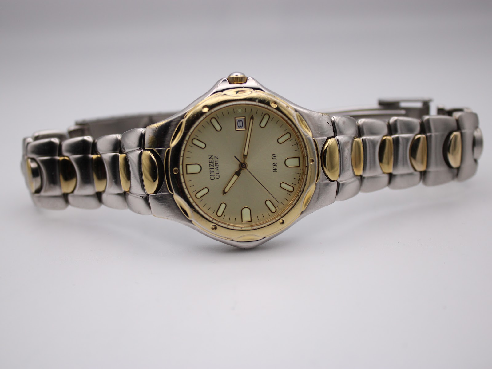 Oblique front view of the Citizen two-tone watch, showing the full bracelet stretched out.