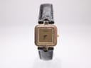 Front view of the Raymond Weil Geneve 5846 watch with gold plated case, crystal bezel, champagne dial, and black leather strap on a white background.
