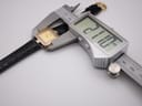 Top-down view of the watch being measured by a digital caliper, displaying a case width of 21.10mm.