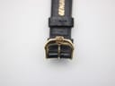Close-up of the gold-tone buckle on the black leather strap, showing the engraved 'RW' logo.
