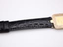 Close-up of the crocodile-embossed pattern on the black genuine leather strap, near the case lugs.