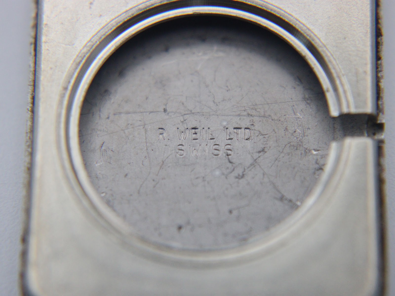 Interior view of the watch case back, showing 'R. WEIL LTD SWISS' engraving on the stainless steel.