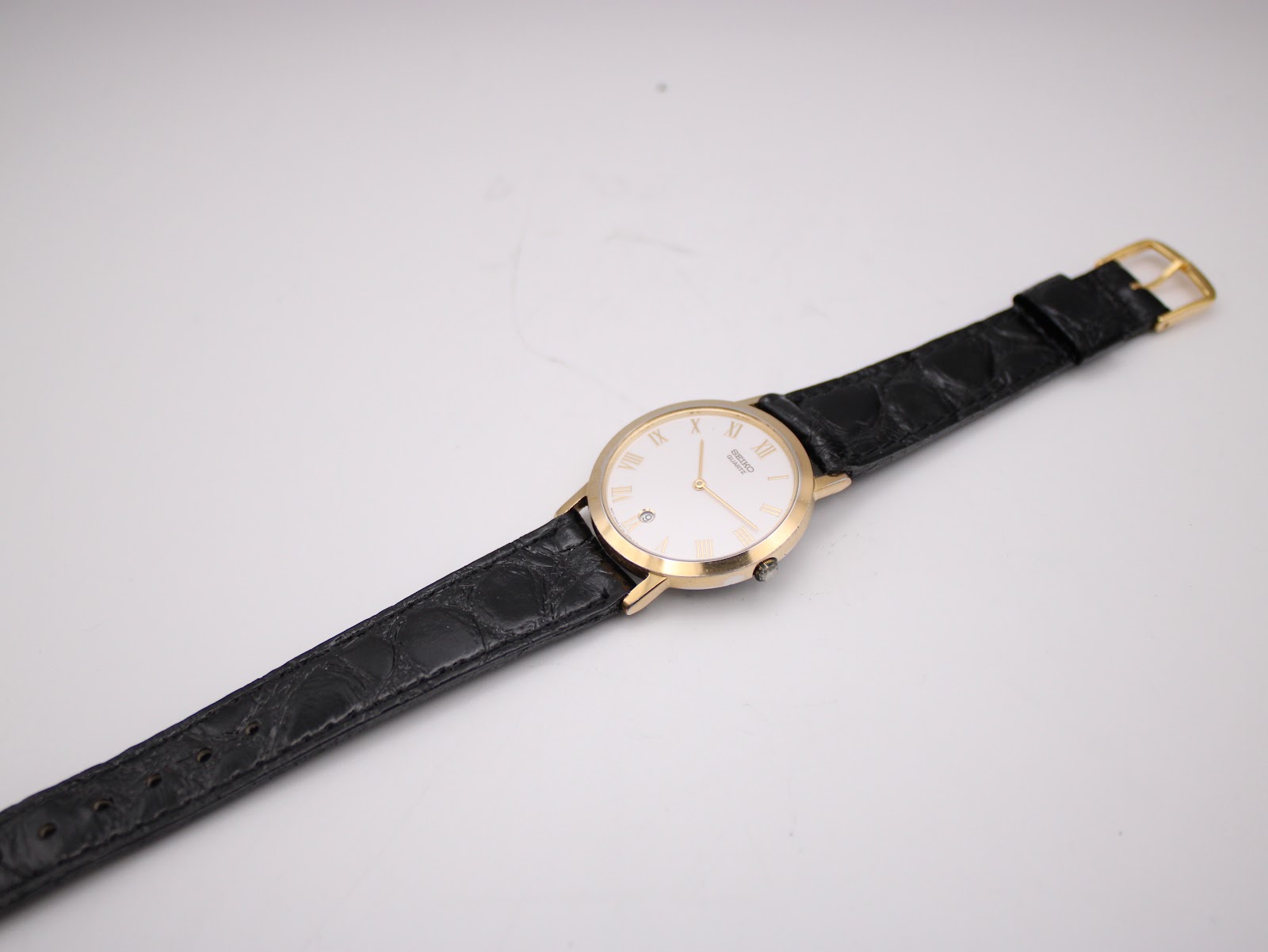 Reverse angle showing black crocodile grain leather strap texture and case back.
