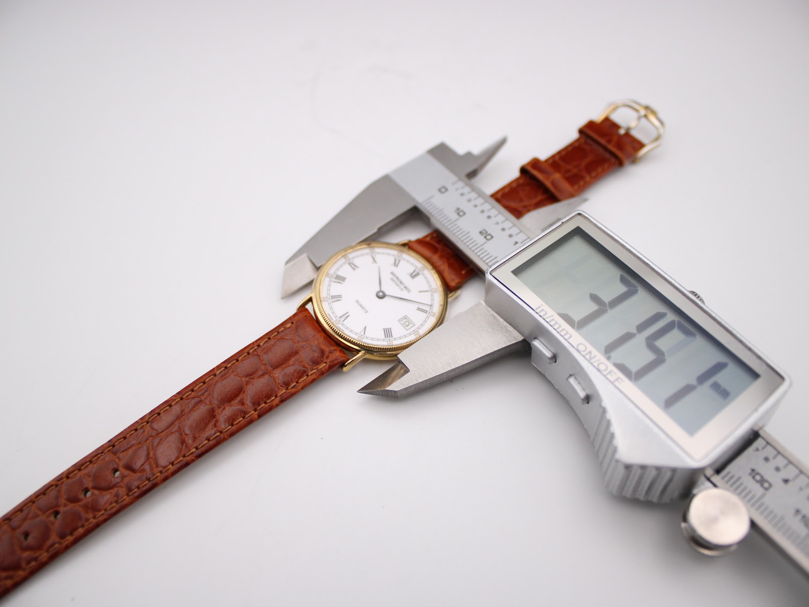 Digital caliper measuring the case diameter of the Raymond Weil 5514 watch, showing a reading of 31.51mm.