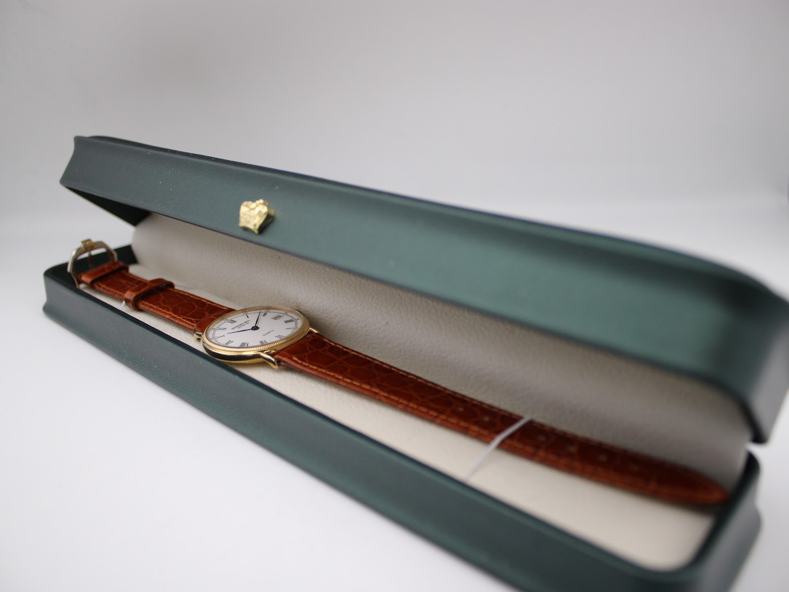 The Raymond Weil 5514 watch placed inside its green aftermarket presentation box.