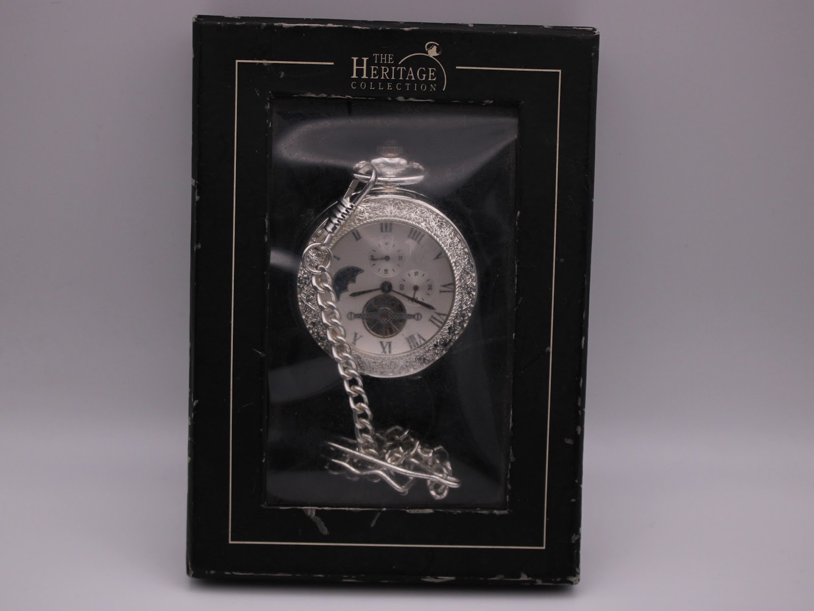The Heritage Collection Spirit of Time pocket watch visible through the window of its closed original presentation box.